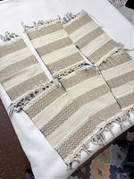 Hand‑woven beige & taupe striped table runner with zig‑zag pattern and fringe tassel accents.