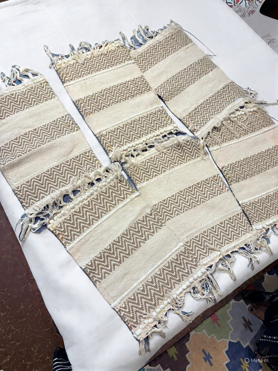 Hand‑woven beige & taupe striped table runner with zig‑zag pattern and fringe tassel accents.